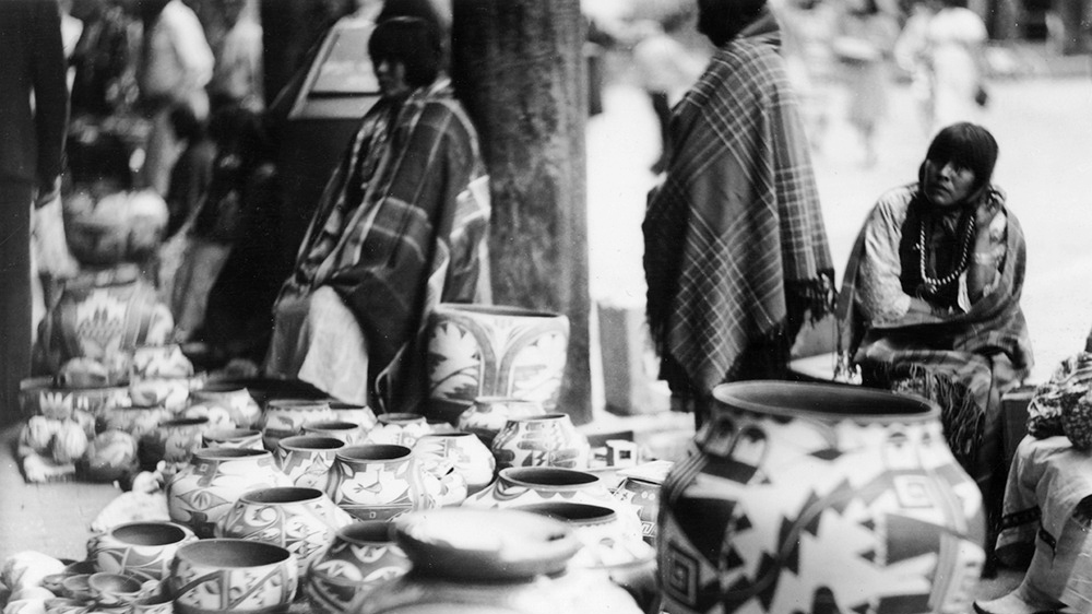 Women selling pottery on Palace of the Governors portal during Indian Market, 1938. Palace of the Governors Photo Archives No. 135047